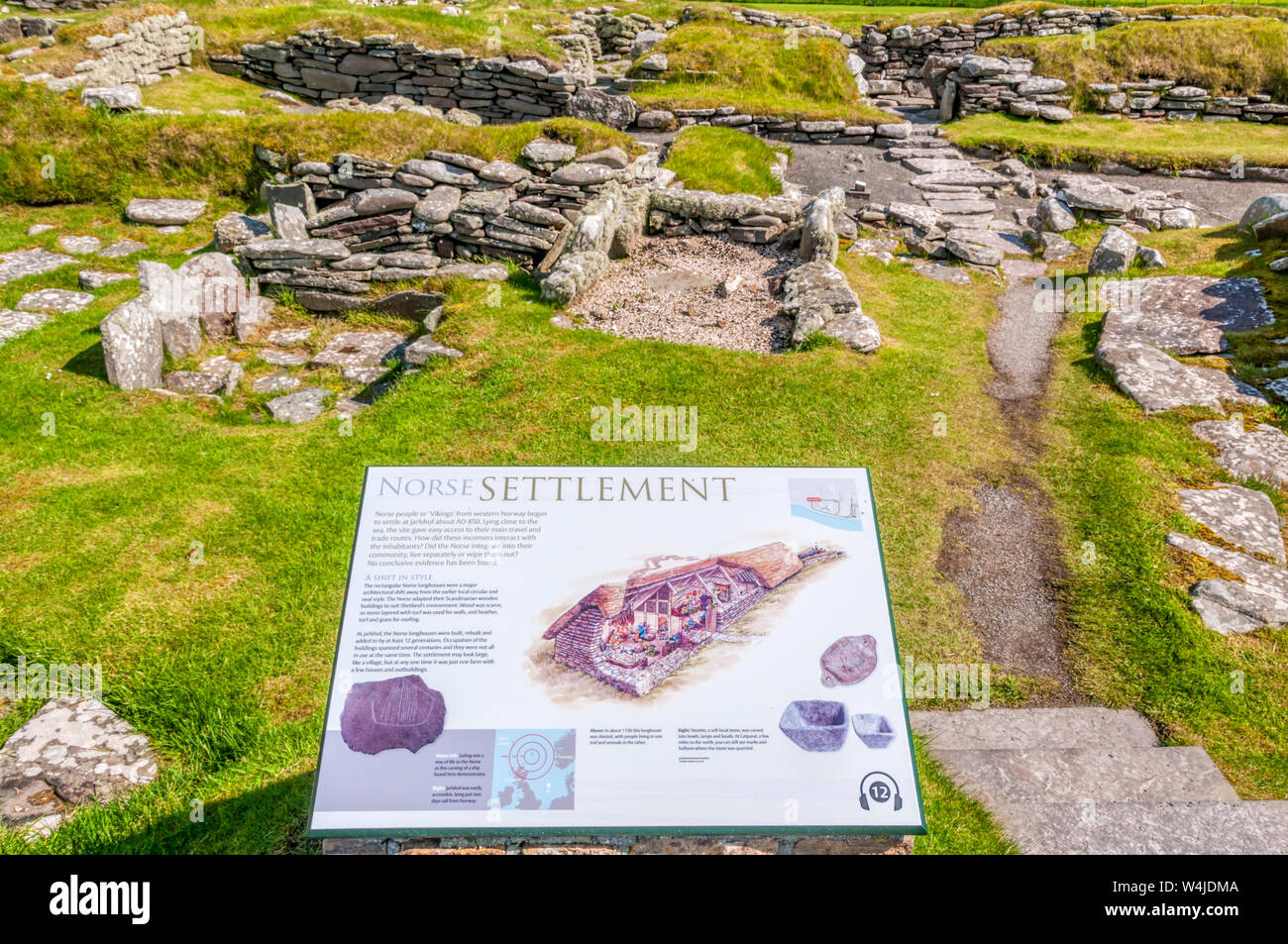 Un segno interpretativa di fronte scavato rimane dell'insediamento dei norvegesi a Jarlshof nel sud del continente, Shetland. Foto Stock