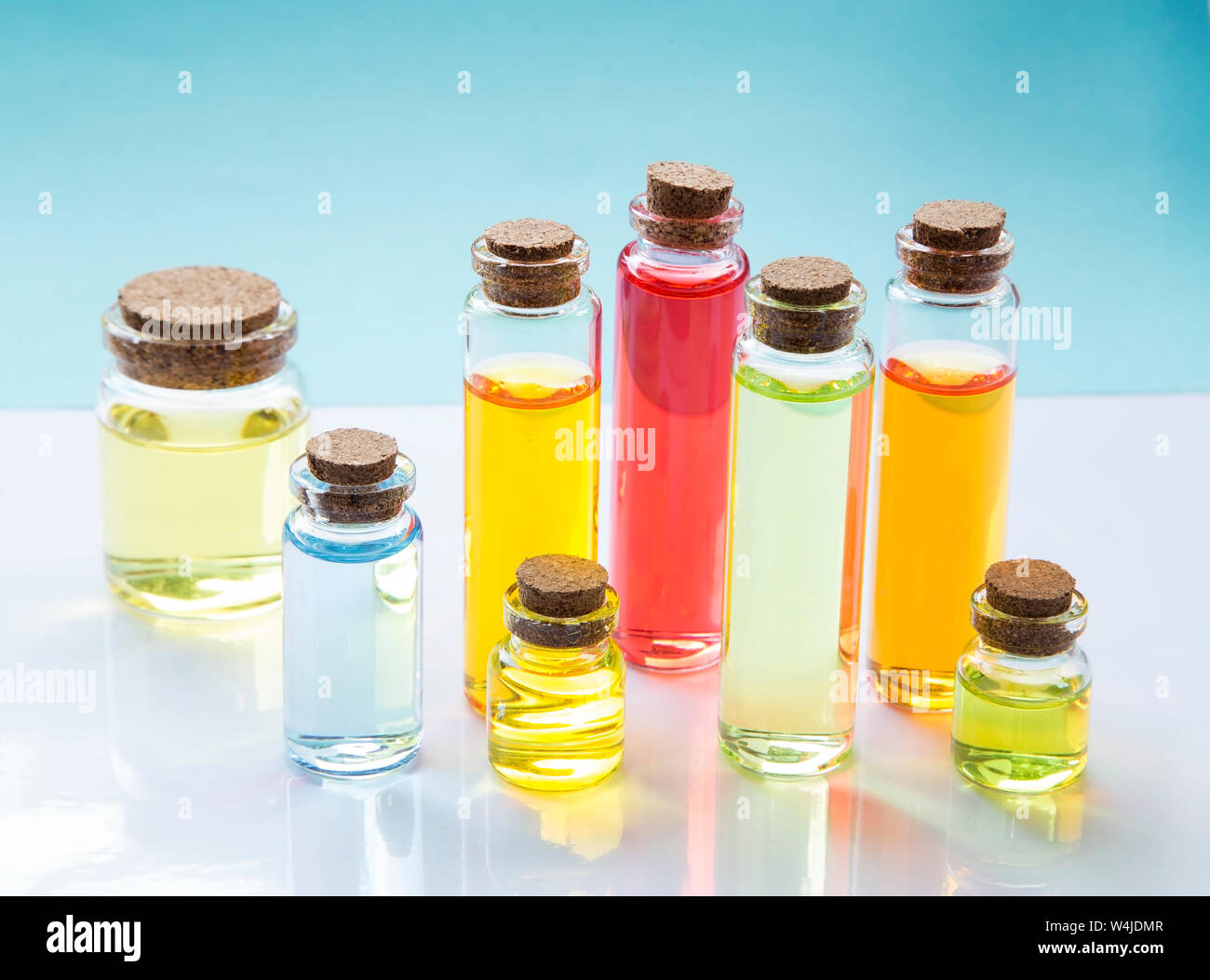 Essenza colorate le bottiglie di olio su sfondo bianco Foto Stock