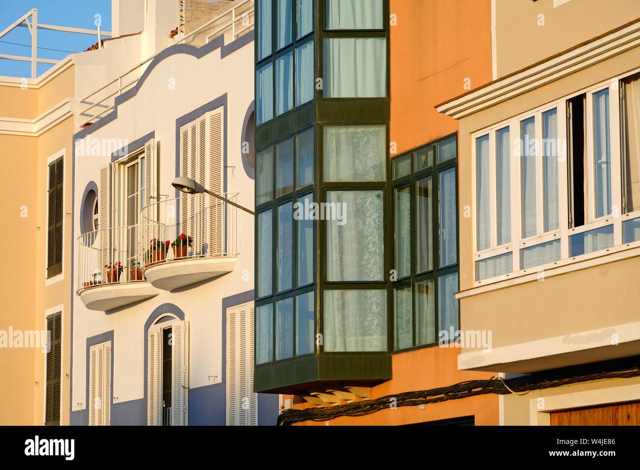 Close up di Windows su appartamenti residenziali e sottratto da una forte luce del sole serale in Ciutadella de Menorca Minorca isole Baleari Spagna Europa Foto Stock