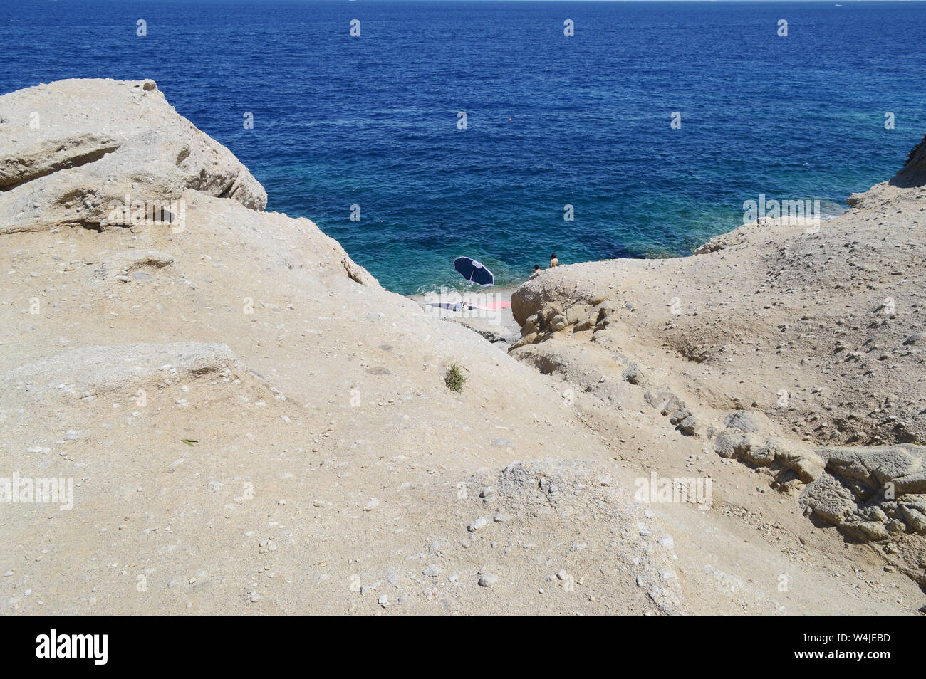 Vista panoramica della costa rocciosa di Sant'Andrea baia dell'isola d'Elba. Un ombrellone isolato sullo sfondo Foto Stock