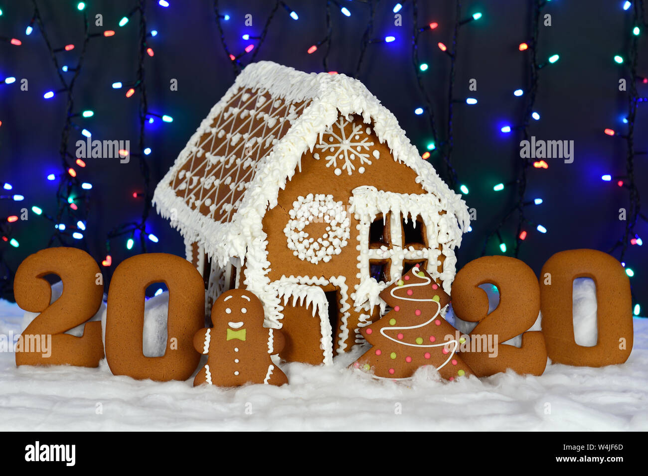 I fatti a mano mangiabile gingerbread house, 2020 iscrizione, piccolo uomo, Nuovo Anno Albero, neve decorazione, ghirlanda di illuminazione di sfondo Foto Stock