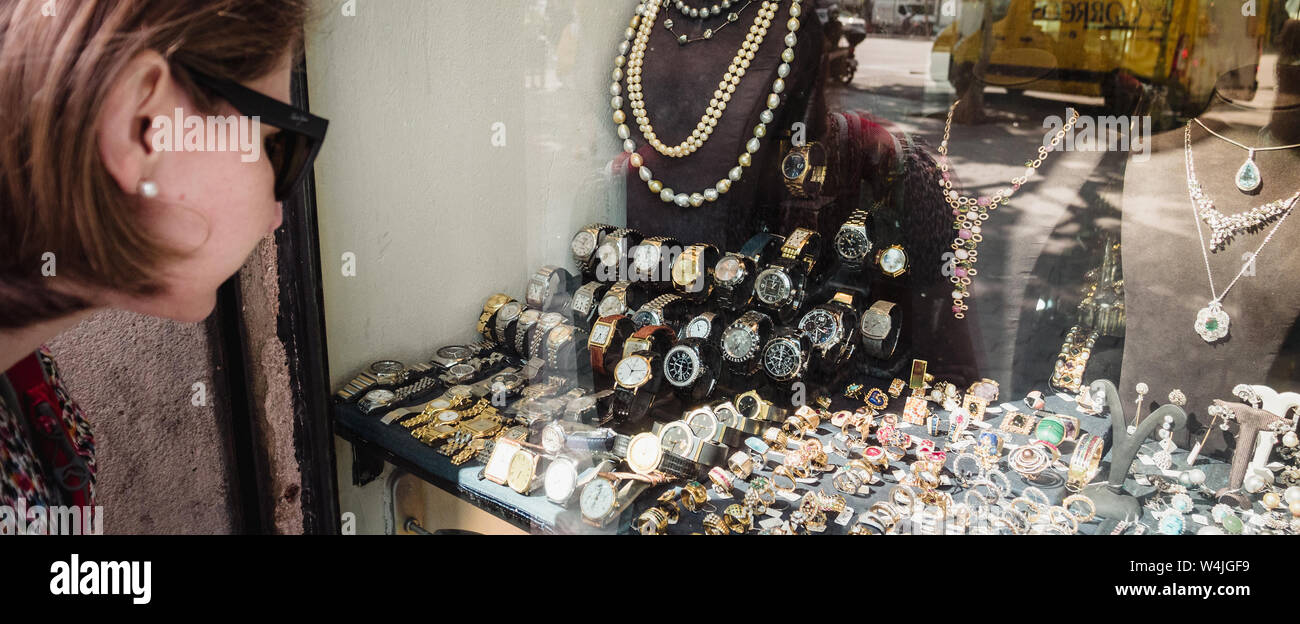 Barcellona, Spagna - 1 Giu 2018: curioso turista eleganti donna che guarda  la parte anteriore vetrina centrale sul negozio gioielli nella città  spagnola la scelta di anelli, orecchini, broches, perle e diamanti