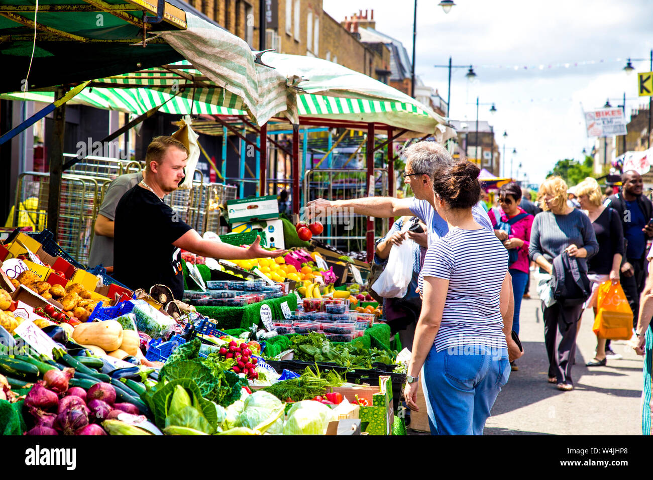 Green grocer stallo con la frutta e la verdura, la gente lo shopping al mercato, il mercato di Chapel, Angelo, London, Regno Unito Foto Stock