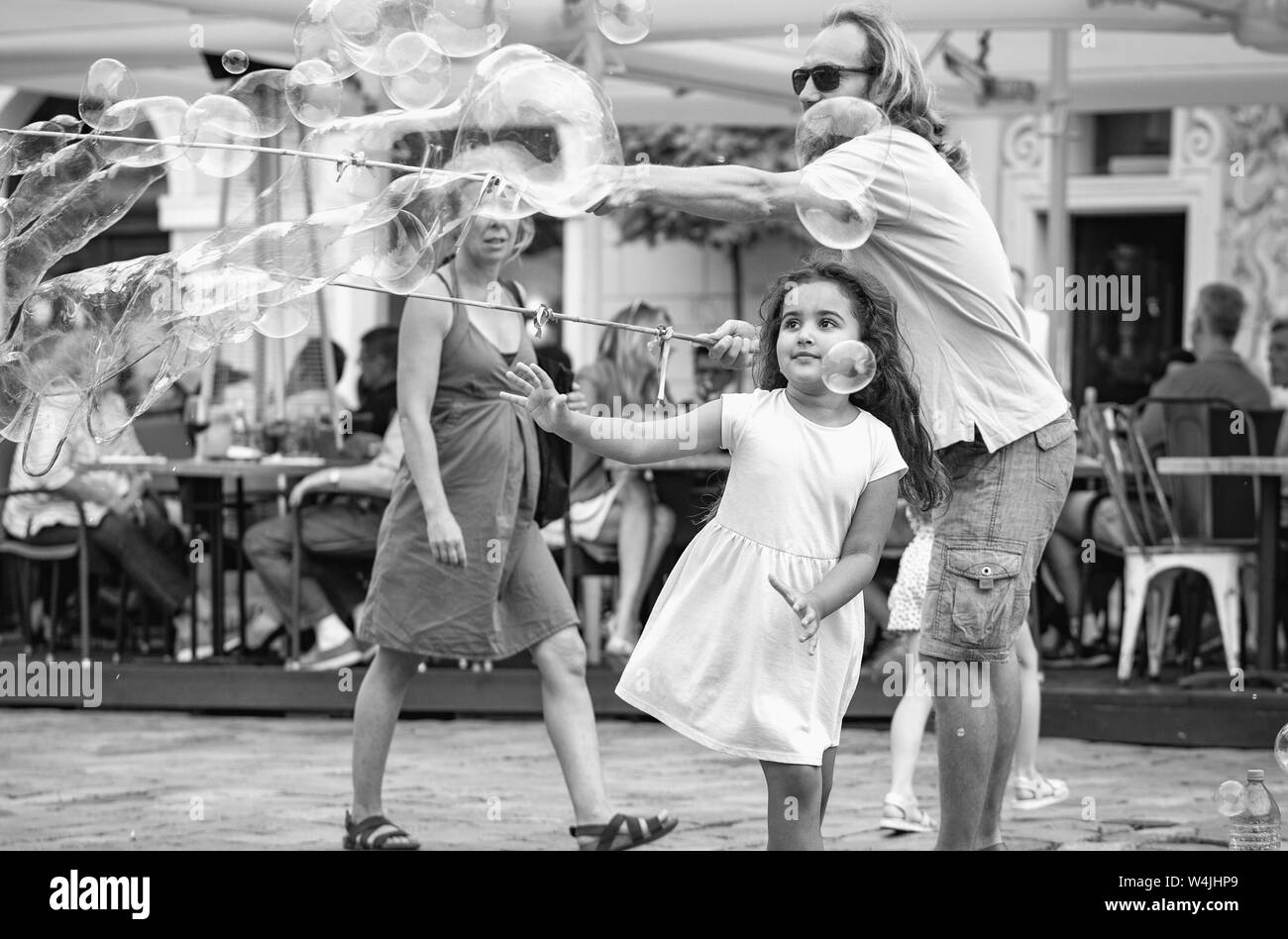 Poznan / Polonia - ragazza a caccia di bolle di sapone. Città vecchia, la piazza del mercato. Foto Stock