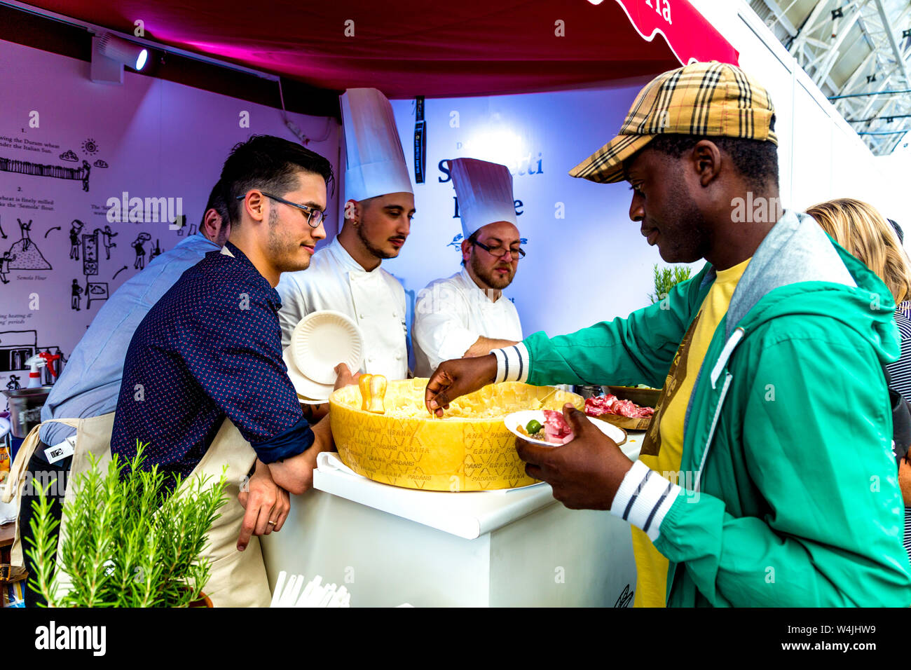 Uomo di campionamento formaggio italiano presso il National Geographic Traveller Food Festival 2019, London, Regno Unito Foto Stock