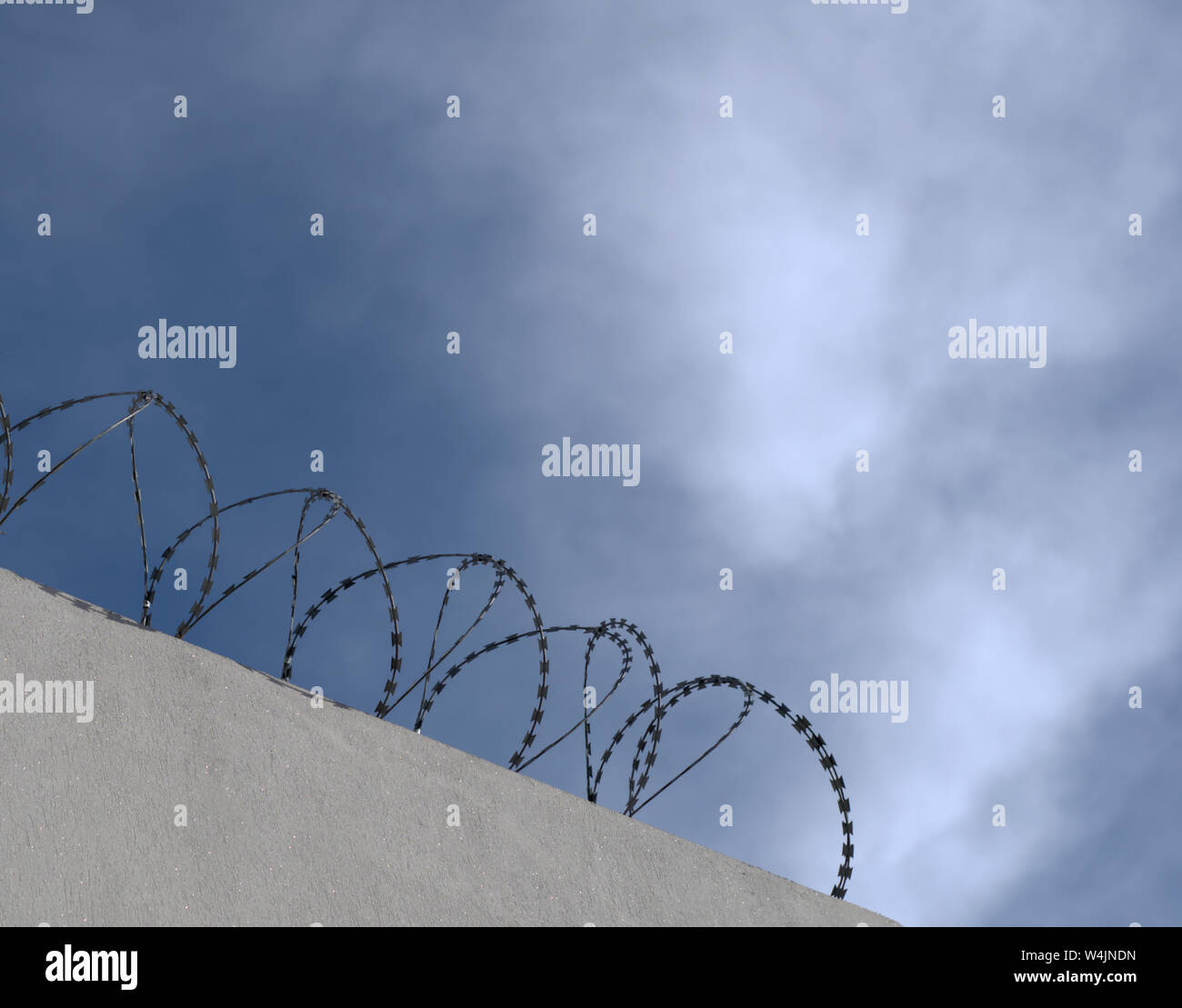 Silhouette di concertina perimetro di filo su una parete Foto Stock