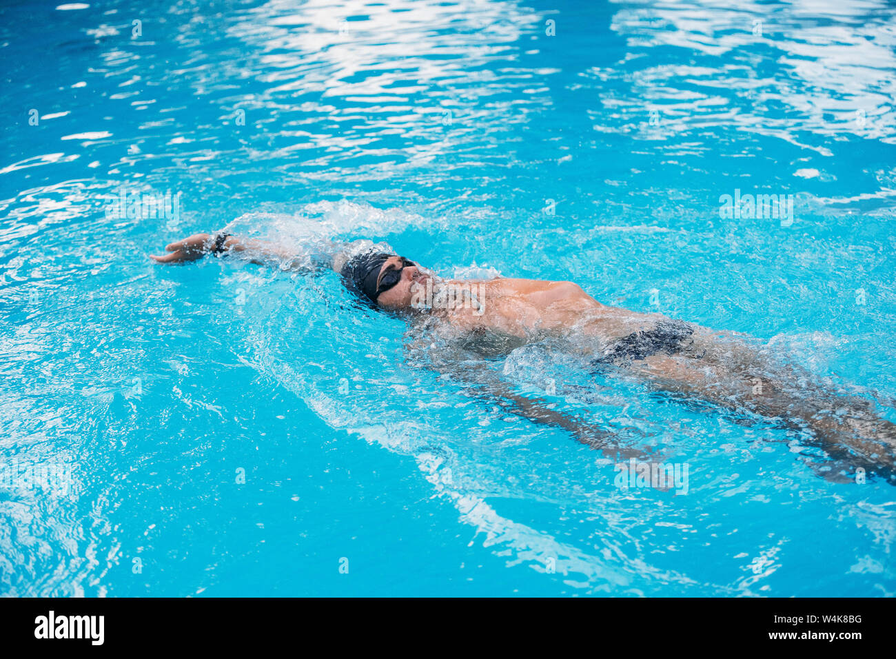 Atletica Giovane uomo nuoto sul dorso di stile. Il nuoto della concorrenza. Foto Stock