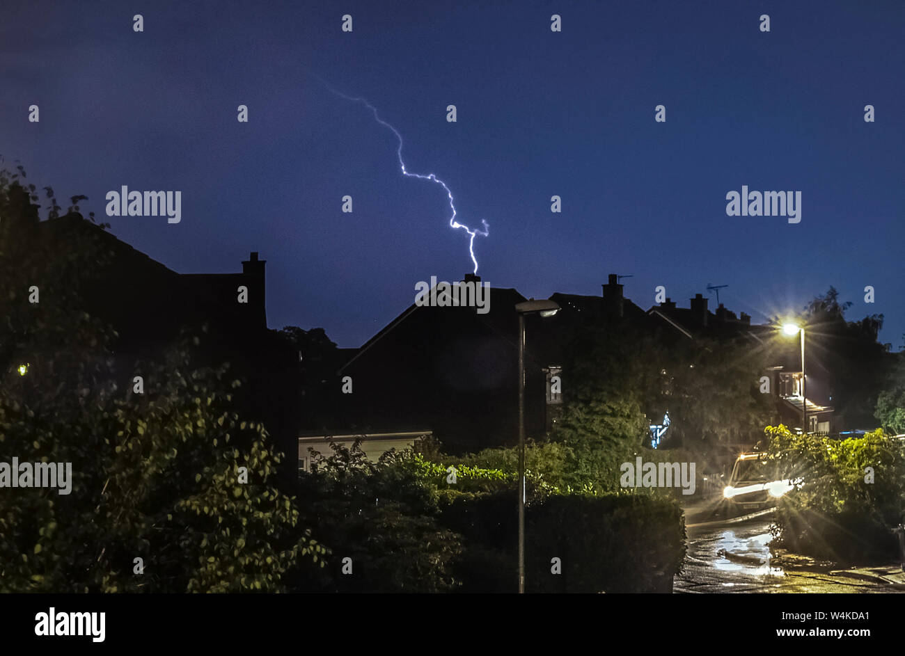Un fulmine colpisce come un temporale passa sopra le case di Leeds, West Yorkshire. Il Regno Unito è previsto a bordo verso il suo sempre più calda giornata di luglio con il mercurio a causa di elevarsi al di sopra di 30C (86F). Foto Stock