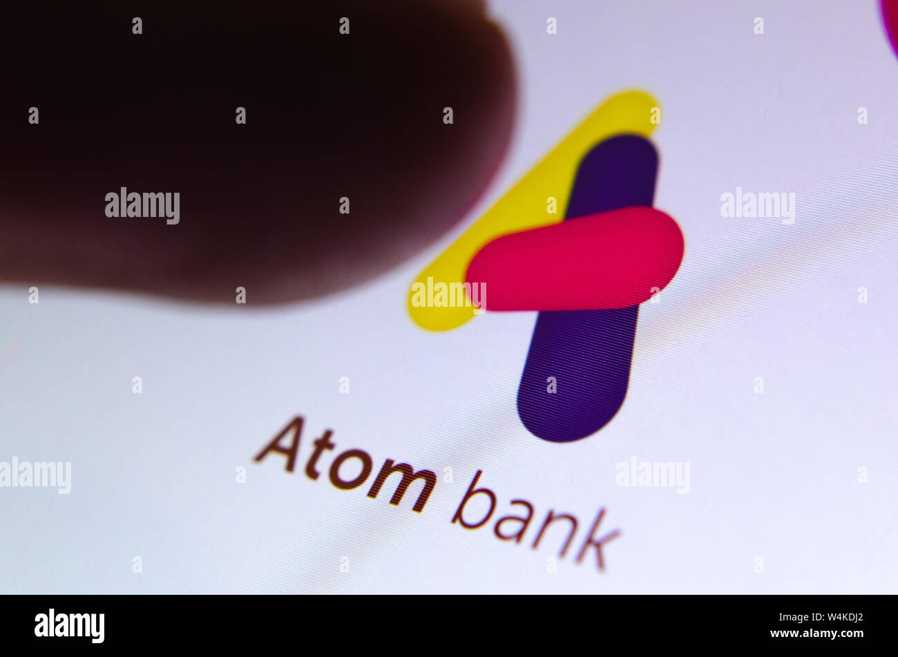 Banca Atom app sullo schermo dello smartphone e il dito circa al tatto. Close up foto. Foto Stock