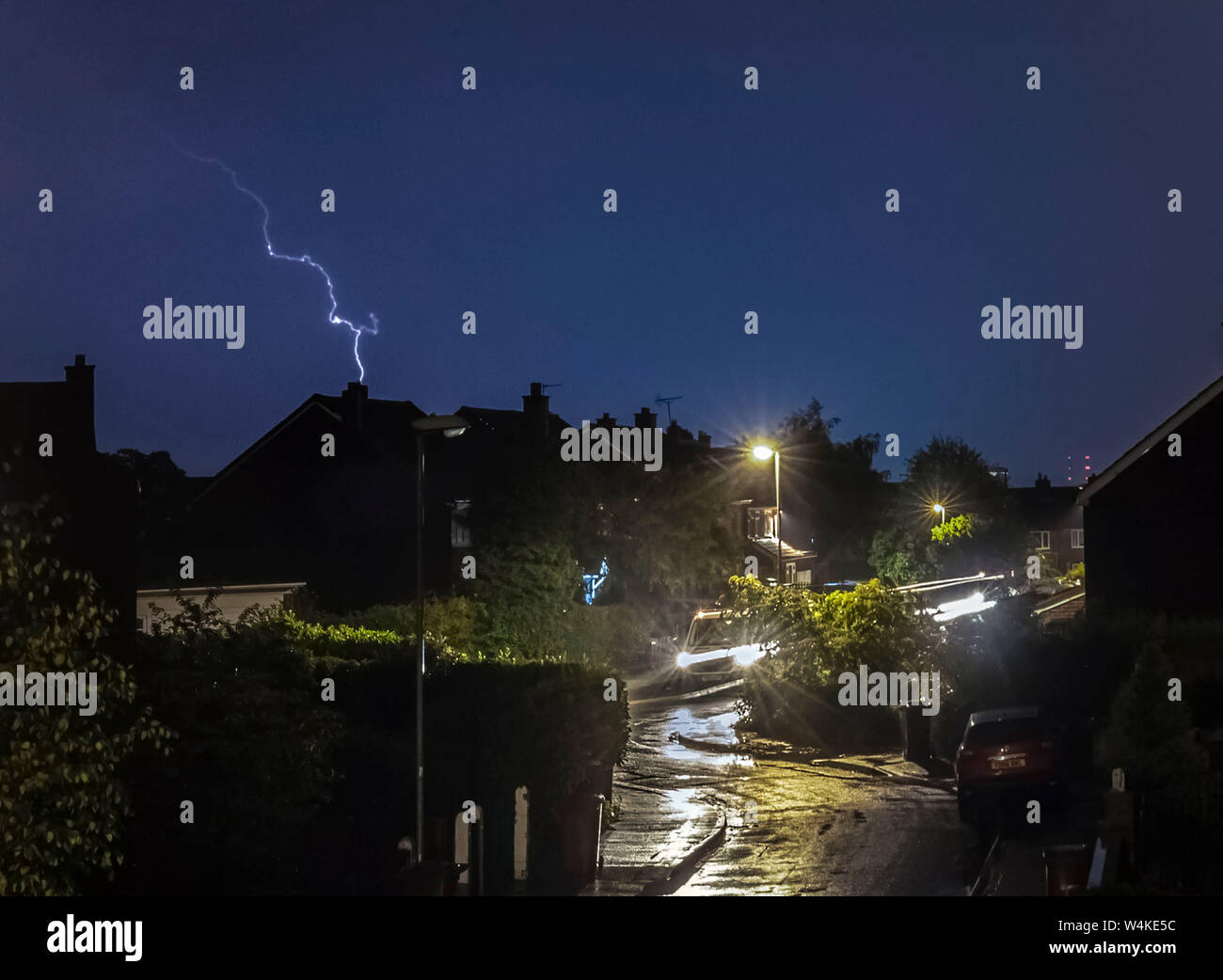 Il fulmine colpisce come un temporale passa sopra le case di Leeds. Il Regno Unito è previsto a bordo verso il suo sempre più calda giornata di luglio con il mercurio a causa di elevarsi al di sopra di 30C (86F). Foto Stock