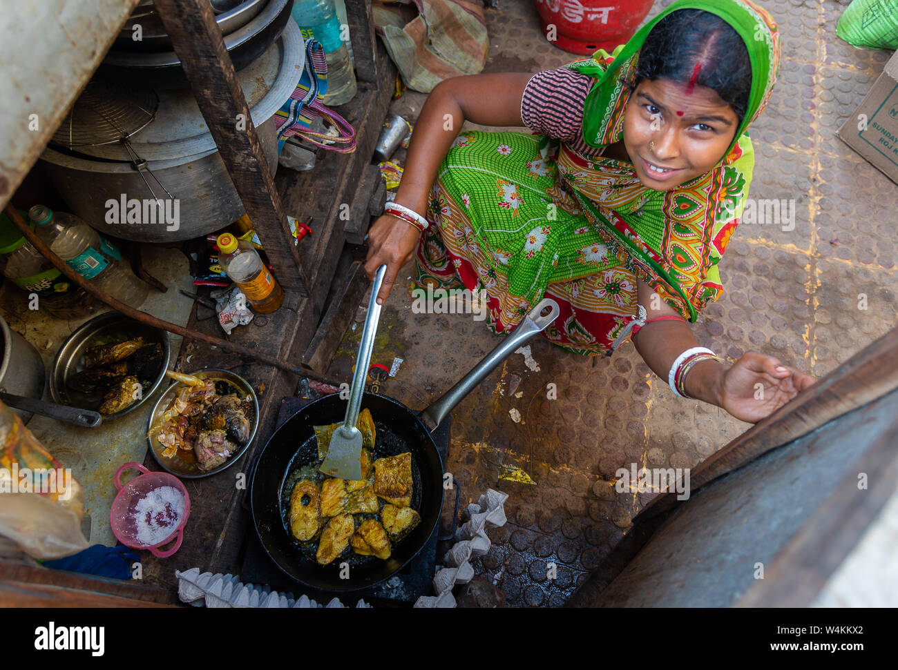 Bichitrapur, Orissa, India. - Maggio 31,2019. Un indiano non identificato donna rurale cucina di pesce con una faccia sorridente. Foto Stock