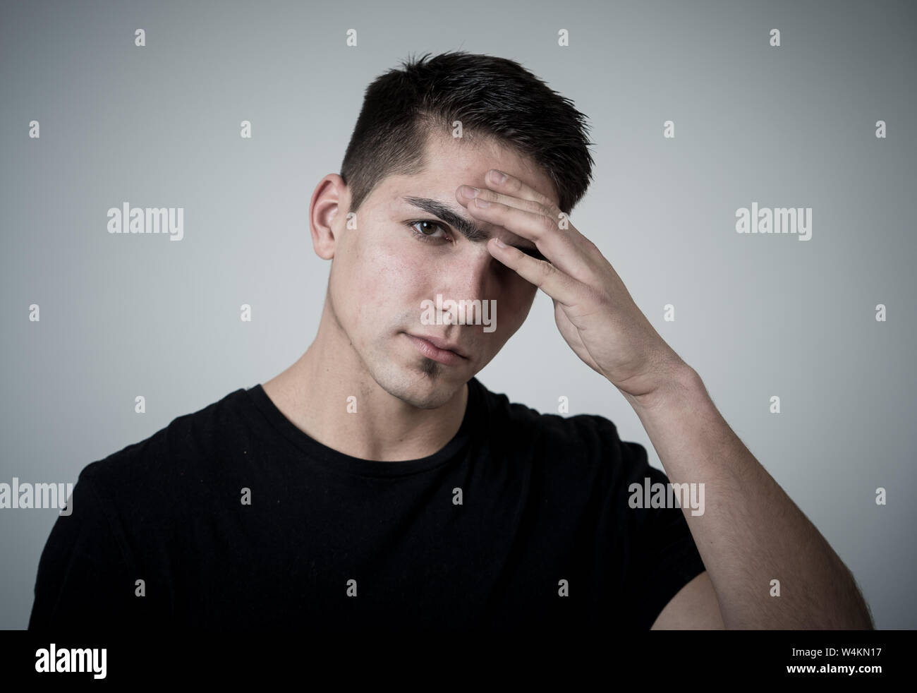 Close up ritratto del bel giovane razza mista uomo con mal di testa che soffre di emicrania, le mani sulle tempie gli occhi chiusi che mostra un forte dolore. Ex del viso Foto Stock