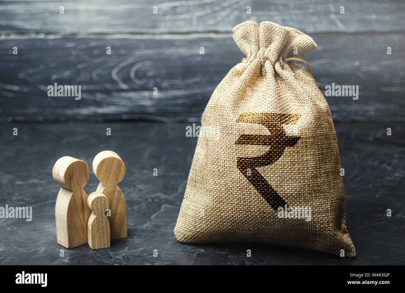 Miniatura in legno figurine famiglia stare vicino a un sacco di denaro. Il concetto di risparmio. Pianificazione del bilancio. Reddito familiare. Distribuzione degli utili. Financial m Foto Stock