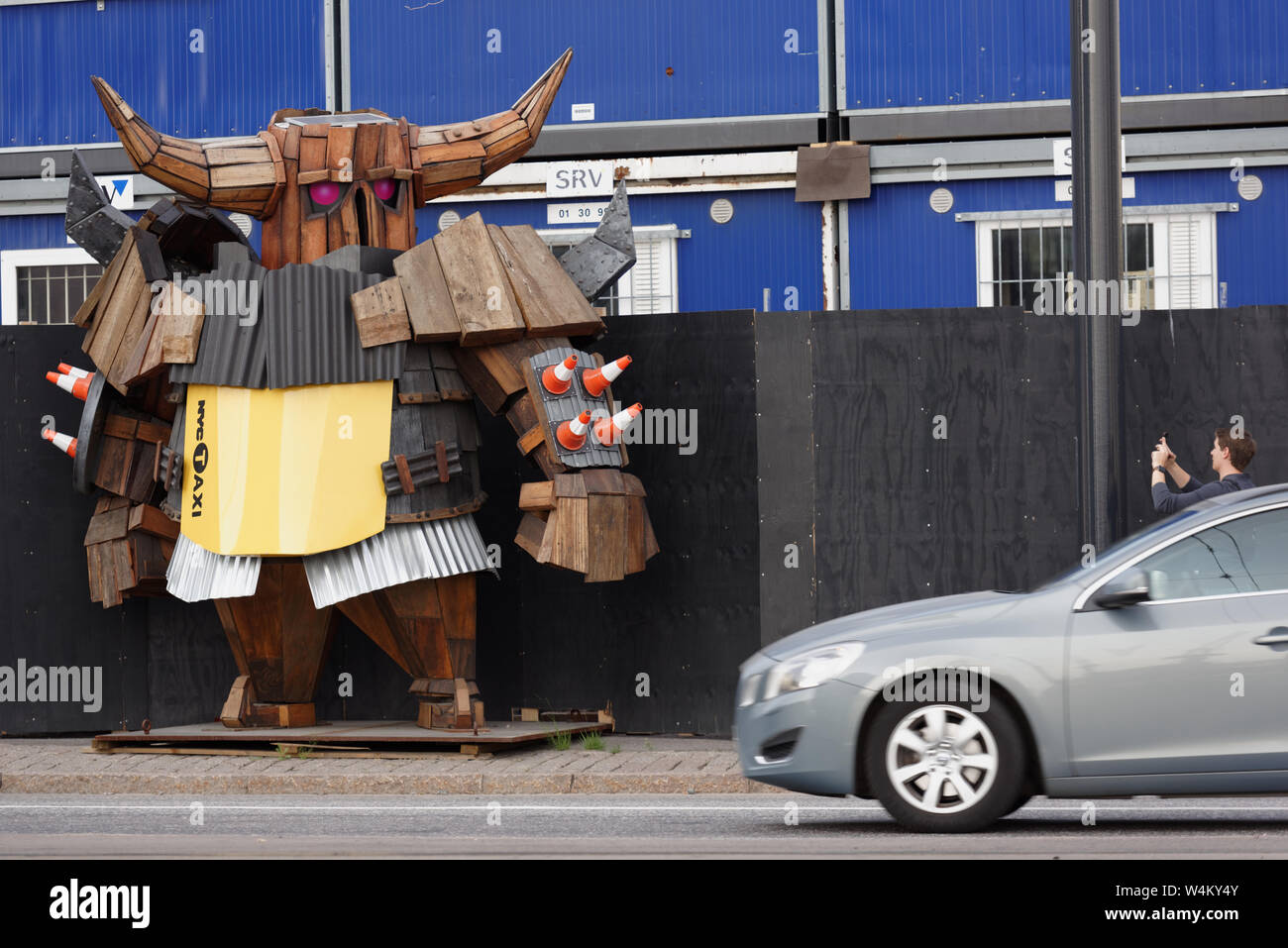 Tourist fare foto di una statua lignea di Viking nel casco alla costruzione ecologica sito sul isola di Jätkäsaari a Helsinki in Finlandia Foto Stock