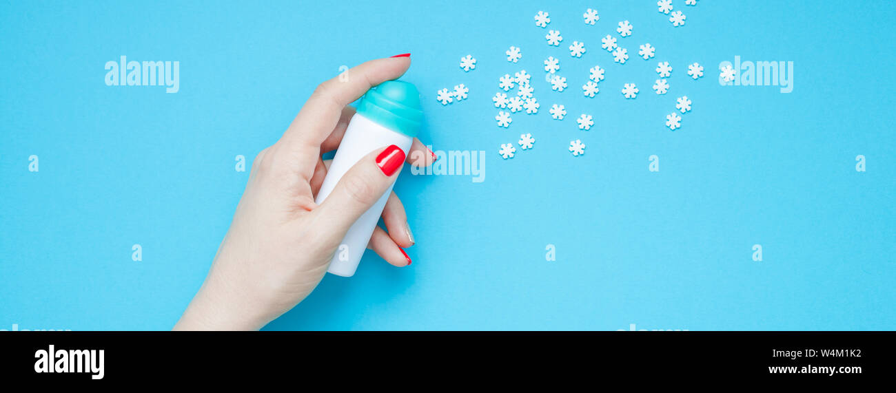 Anno nuovo o di Natale top view Xmas holiday celebrazione donna rosso a mano manicure con la bottiglia spray rendendo i fiocchi di neve spazio copia blu turchese colore pa Foto Stock