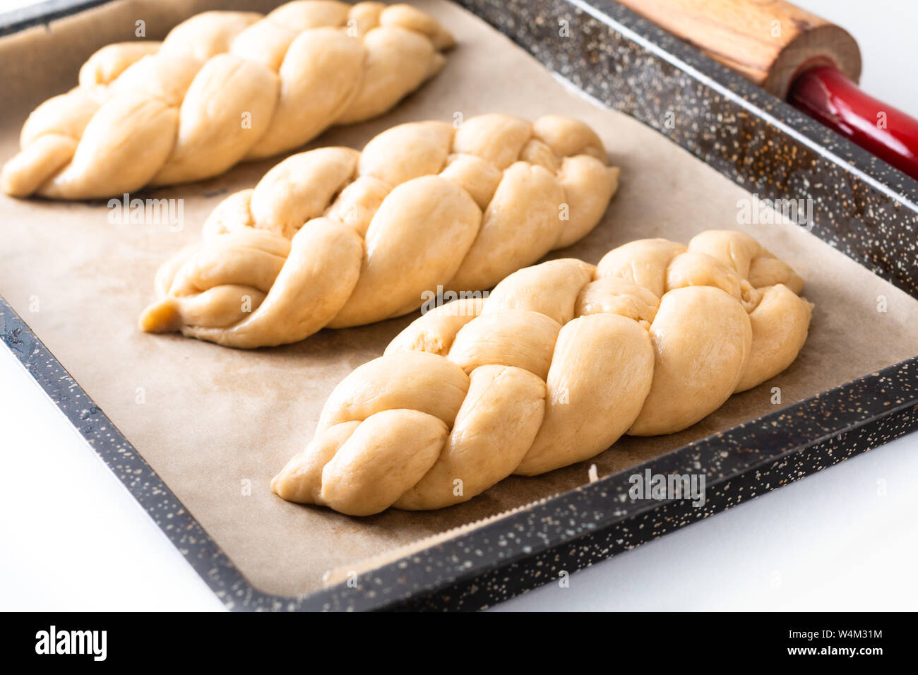 Cibo fatto in casa concetto processo risultava treccia di pane challah impasto su sfondo bianco con spazio di copia Foto Stock