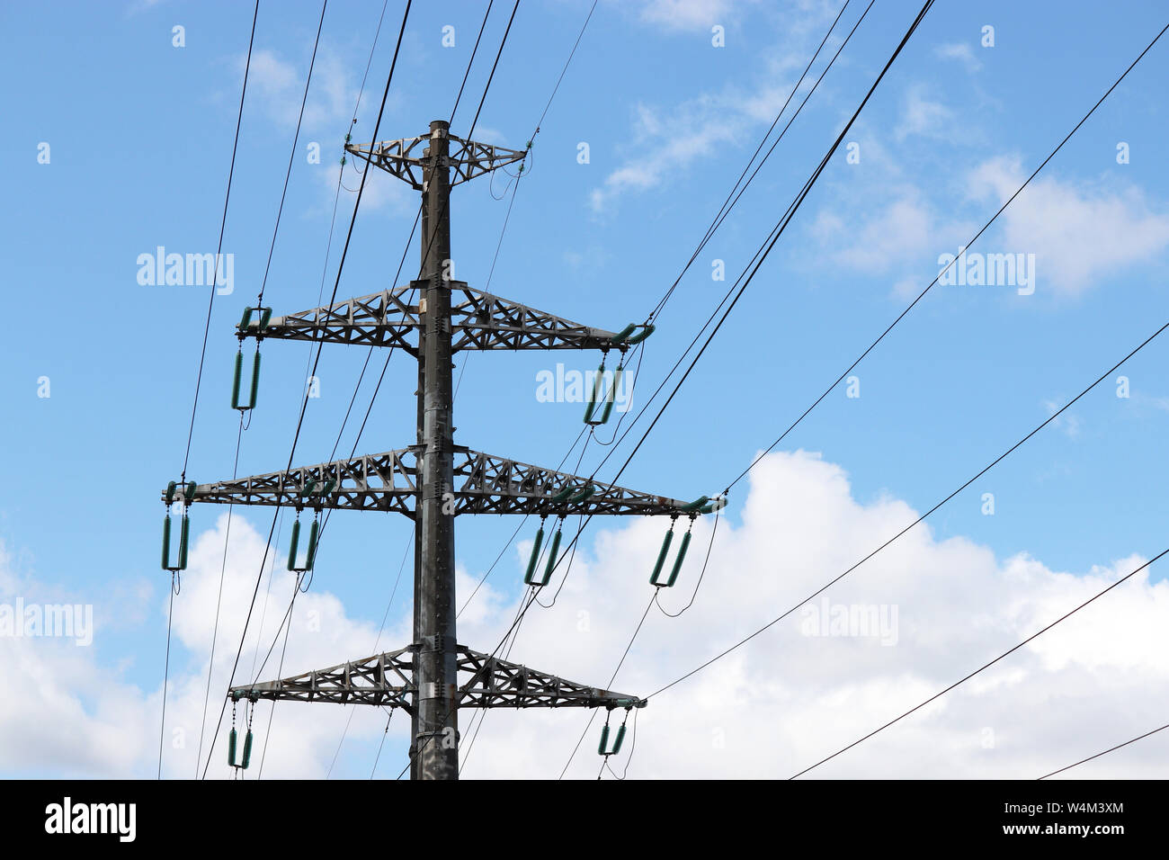 Tensione alta torri con fili elettrici sul cielo blu e nuvole bianche sfondo. Linee di trasmissione di energia elettrica, alimentazione concept Foto Stock