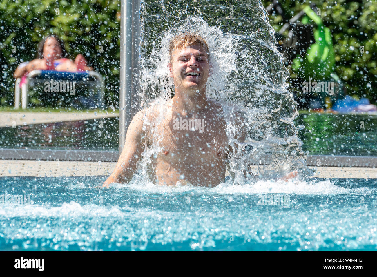 24 luglio 2019, il Land della Baviera, Passau: Jonas si raffredda sotto una cascata nella piscina all'aperto "peb'. La Germania si trova di fronte a un'ondata di calore - e già mercoledì questo sarà chiaramente evidente in molti settori. Foto: Armin Weigel/dpa Foto Stock