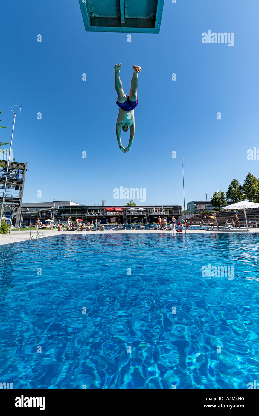 24 luglio 2019, il Land della Baviera, Passau: Andreas salti in acqua fresca nella piscina all'aperto "peb'. La Germania si trova di fronte a un'ondata di calore - e già mercoledì questo sarà chiaramente evidente in molti settori. Foto: Armin Weigel/dpa Foto Stock