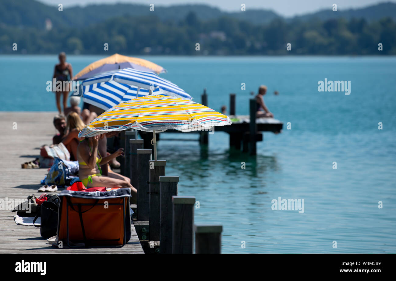 24 luglio 2019, il Land della Baviera, Inning: numerosi escursionisti di sedersi su un molo al worthsee nel sole e temperature elevate. Foto: Sven Hoppe/dpa Foto Stock