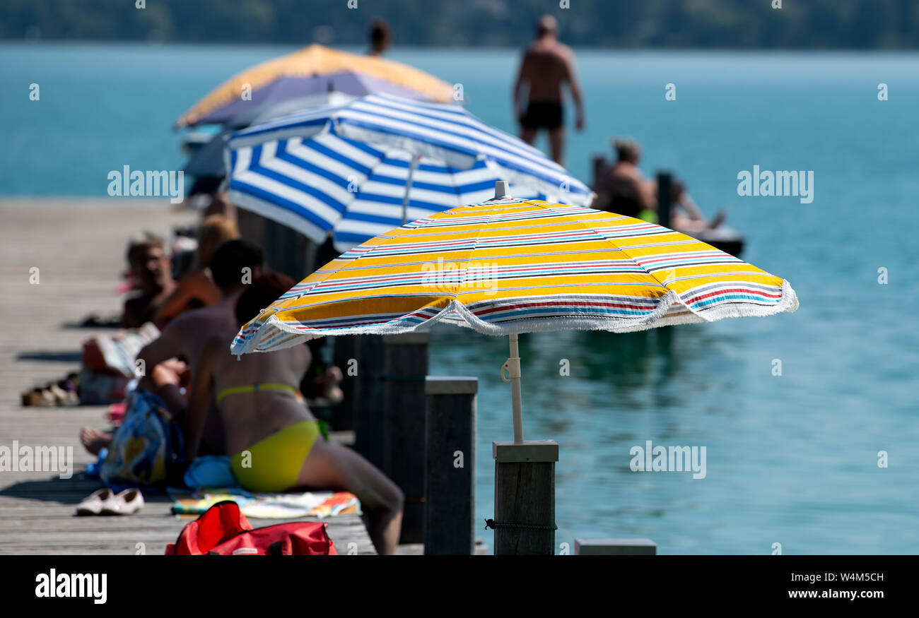 24 luglio 2019, il Land della Baviera, Inning: numerosi escursionisti di sedersi su un molo al worthsee nel sole e temperature elevate. Foto: Sven Hoppe/dpa Foto Stock