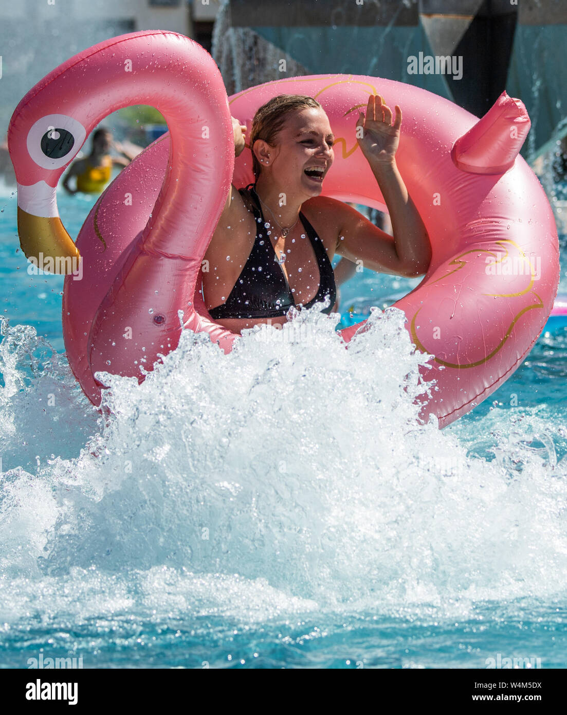 24 luglio 2019, in Sassonia, Großröhrsdorf: Antje da Dresda è divertito con una nuotata in un pneumatico in forma di un pellicano nella massa bagno d'uovo nel distretto di Bautzen. Foto: Robert Michael/dpa-Zentralbild/dpa Foto Stock