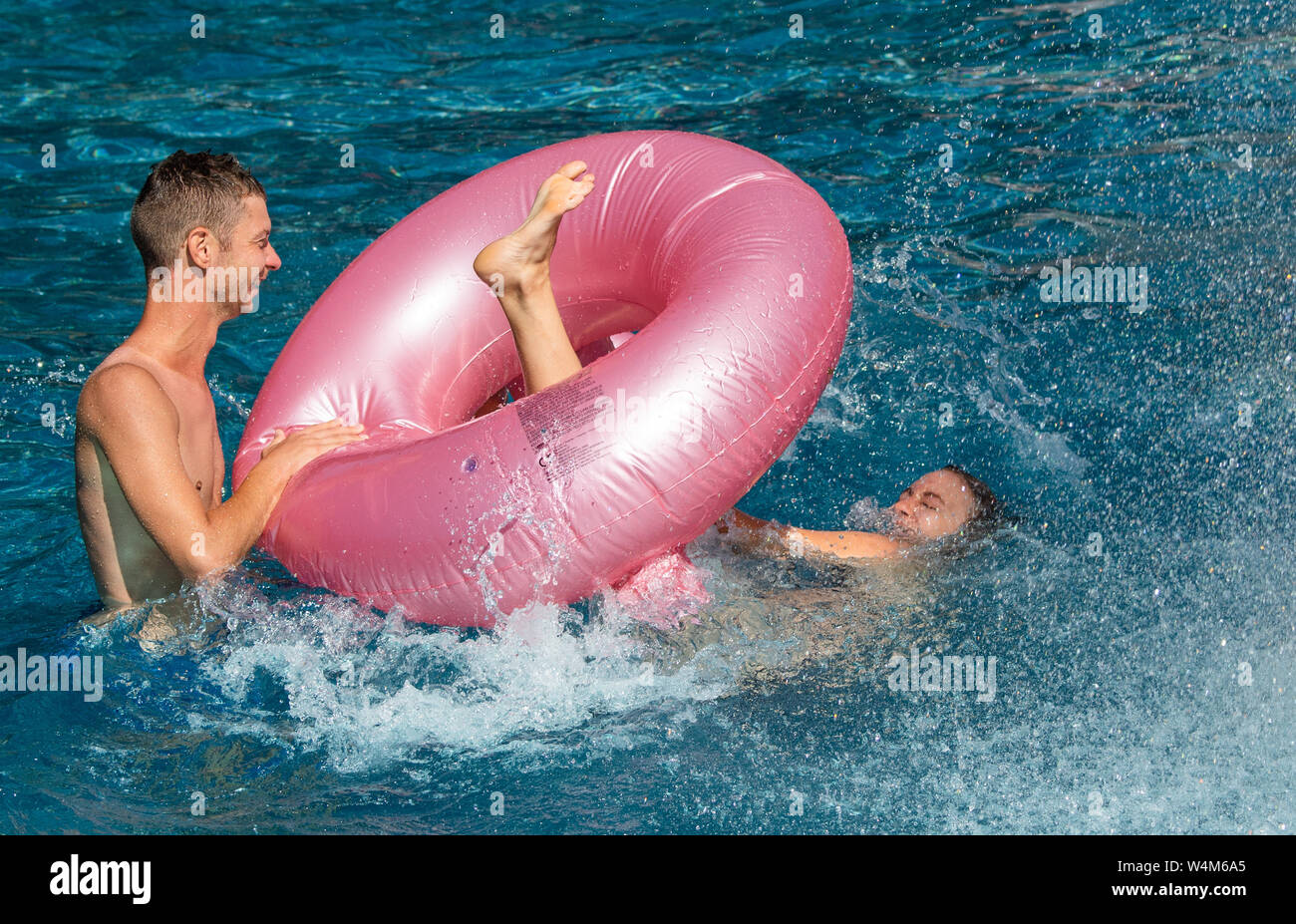 24 luglio 2019, in Sassonia, Großröhrsdorf: Antje e Stefan da Dresda si divertono con un pneumatico di nuoto nel Massenei-Bad nel distretto di Bautzen. Foto: Robert Michael/dpa-Zentralbild/dpa Foto Stock
