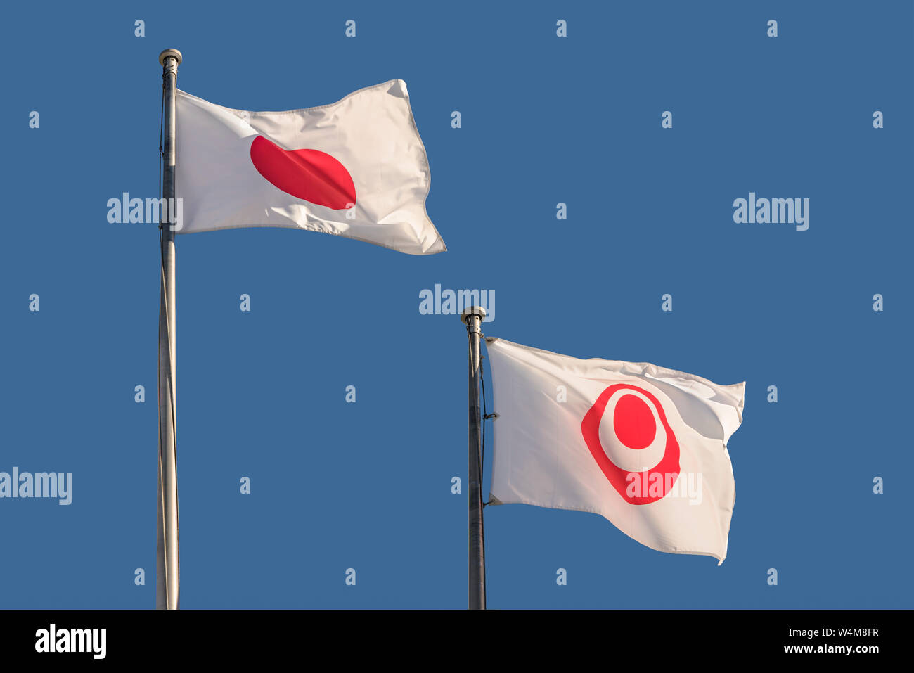 Due bandiere del Giappone e la città di naha floating sotto il cielo blu Foto Stock