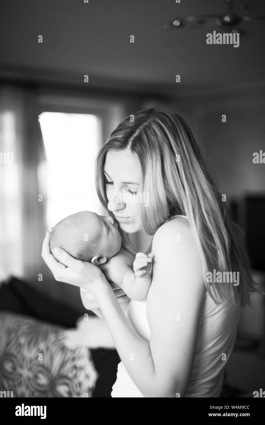 In bianco e nero la foto in stile retrò - happy madre tenendo un neonato sullo sfondo di una stanza per bambini Foto Stock