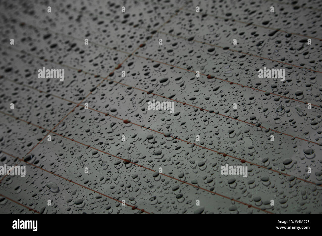 Le gocce di pioggia sulla superficie nera Foto Stock