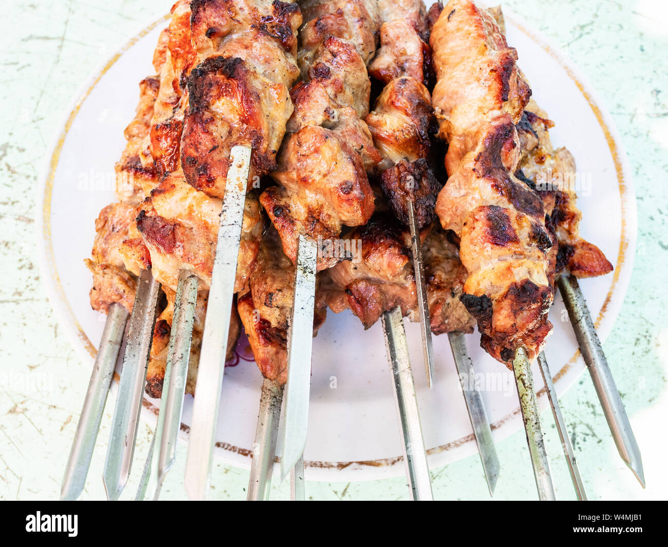 Molti cotta calda infilzato shish kebab (shashlyk) da carne di maiale close-up sulla piastra alla tabella esterna Foto Stock