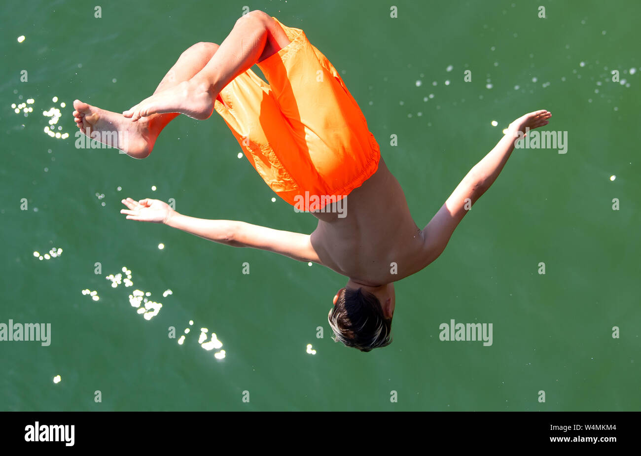 24 luglio 2019, il Land della Baviera, Utting: un ragazzo salta al lido Utting nell'Ammersee nel sole e temperature elevate. Foto: Sven Hoppe/dpa Foto Stock