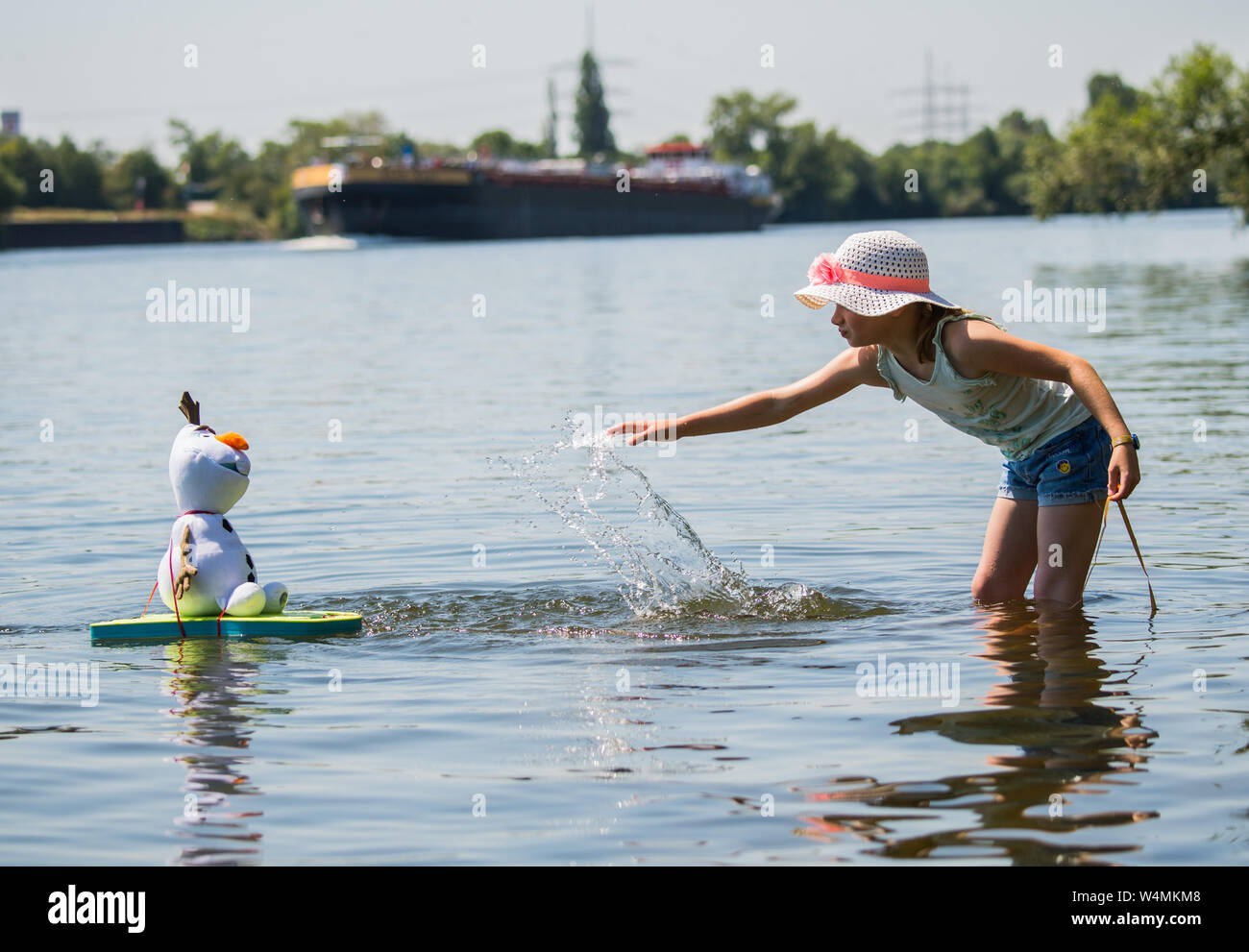 24 luglio 2019, Assia, Flörsheim: La ragazza Lilith aggiorna il suo tessuto pupazzo di Olaf, la figura del film Disney " Snow Queen', in questa giornata calda con acqua dalla principale nei pressi di Flörsheim. Foto: Andreas Arnold/dpa Foto Stock