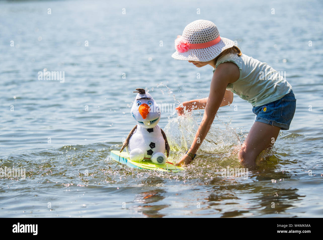 24 luglio 2019, Assia, Flörsheim: La ragazza Lilith aggiorna il suo tessuto pupazzo di Olaf, la figura del film Disney " Snow Queen', in questa giornata calda con acqua dalla principale nei pressi di Flörsheim. Foto: Andreas Arnold/dpa Foto Stock