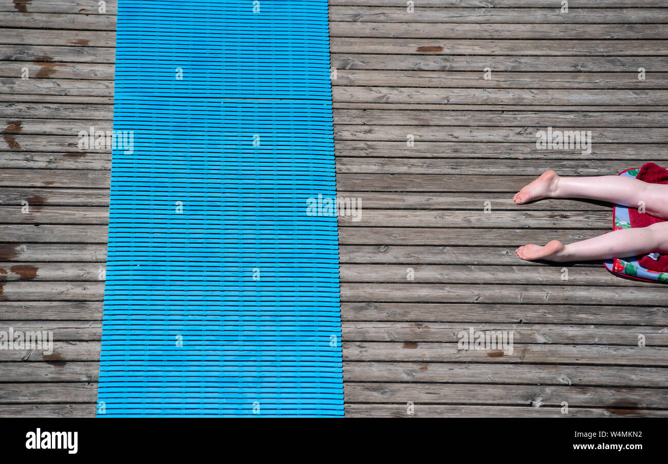 24 luglio 2019, il Land della Baviera, Utting: una donna giace su un molo del Lido Utting nel sole e temperature elevate. Foto: Sven Hoppe/dpa Foto Stock