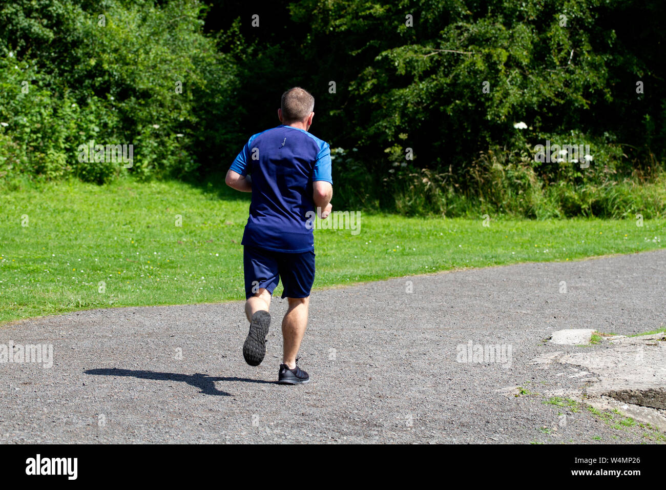 Dundee, Tayside, Scotland, Regno Unito. Il 24 luglio, 2019. Meteo REGNO UNITO: caldo clima soleggiato con temperature fino a 25º Celsius. Un pareggiatore maschio jogging intorno al paese Clatto Park a Dundee, Regno Unito. Credito: Dundee fotografico / Alamy Live News Foto Stock