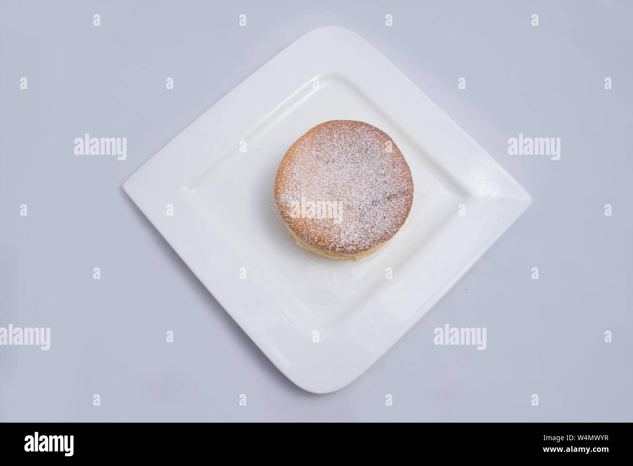 Un basso contrasto Hero Shot di una torta di pan su una piastra su un minimo di sfondo bianco con una diagonale di 60 gradi Foto Stock