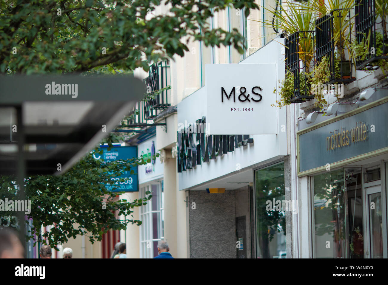 Gli amanti dello shopping passeggiando per Cheltenham centro storico passato di moda britannica di negozio di abbigliamento - Superdry Foto Stock