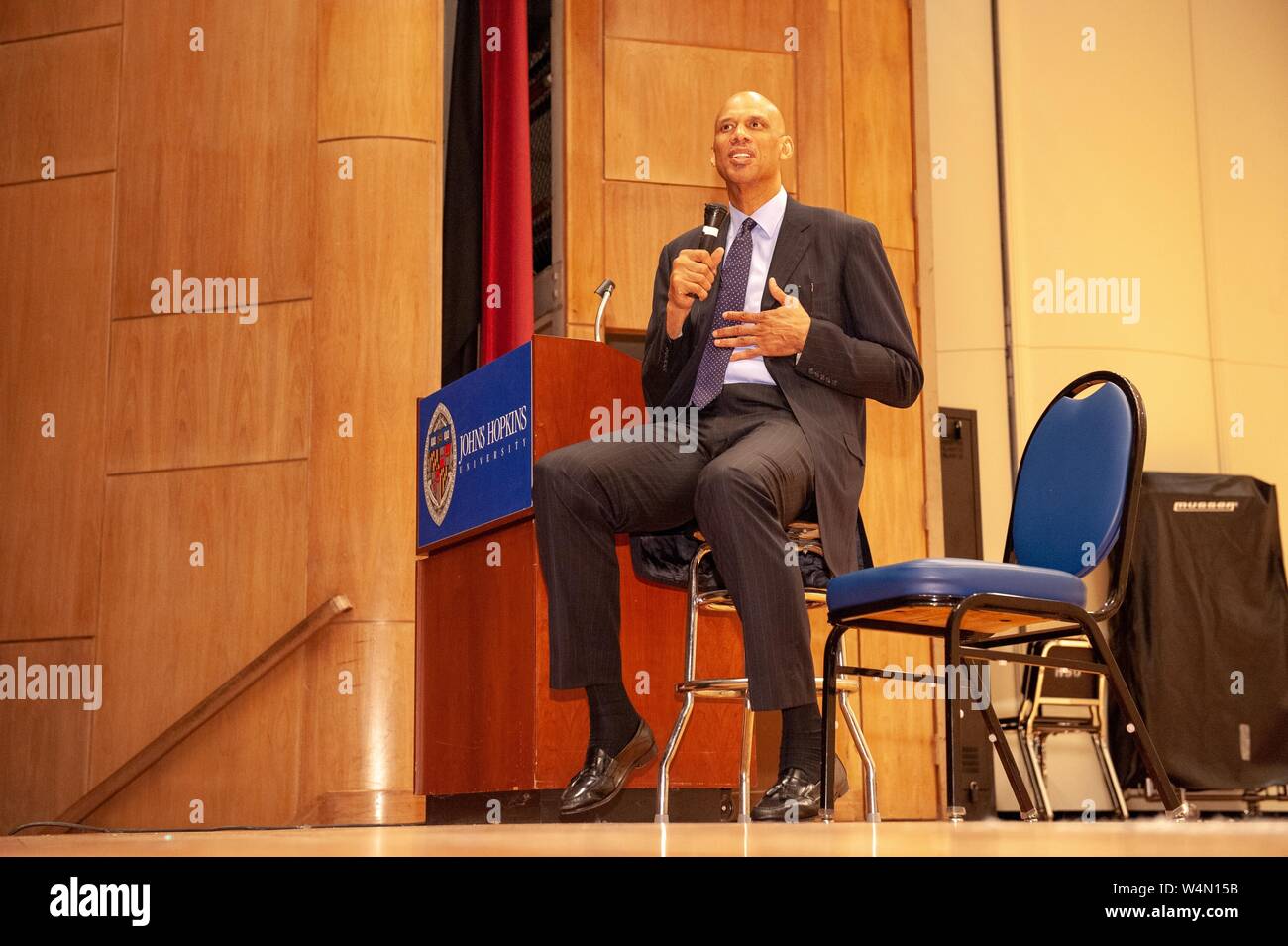 Inquadratura dal basso del critico culturale e ritirato atleta Kareem Abdul-Jabbar, seduti su uno sgabello come egli parla a Milton S Eisenhower simposio presso la Johns Hopkins University, Baltimora, Maryland, 28 ottobre 2008. Dall'Homewood raccolta di fotografie. () Foto Stock