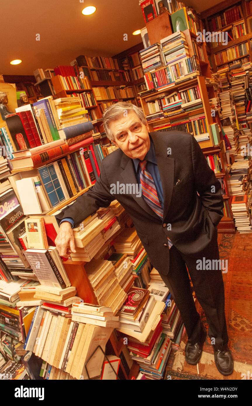 Elevato angolo di close-up di scienze umanistiche il professor Richard un Macksey, poggiando su una pila di libri, probabilmente nella biblioteca privata egli lasciò in eredità alla Johns Hopkins University di Baltimore, Maryland, Dicembre 14, 2006. Dall'Homewood raccolta di fotografie. () Foto Stock