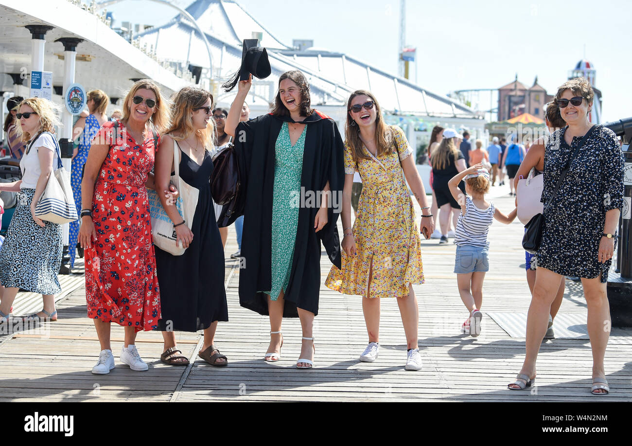 Brighton Regno Unito 24 luglio 2019 - Mathilde Compagnon celebra la laurea presso la University of Sussex con una passeggiata con la famiglia e gli amici su Brighton Palace Pier come il caldo clima soleggiato continua in tutta la Gran Bretagna . L'ondata di caldo in condizioni meteo per continuare domani e le temperature sono attesi per colpire i nuovi record con esso di raggiungere alte come 39 gradi Celsius a Londra . Credito: Simon Dack / Alamy Live News Foto Stock