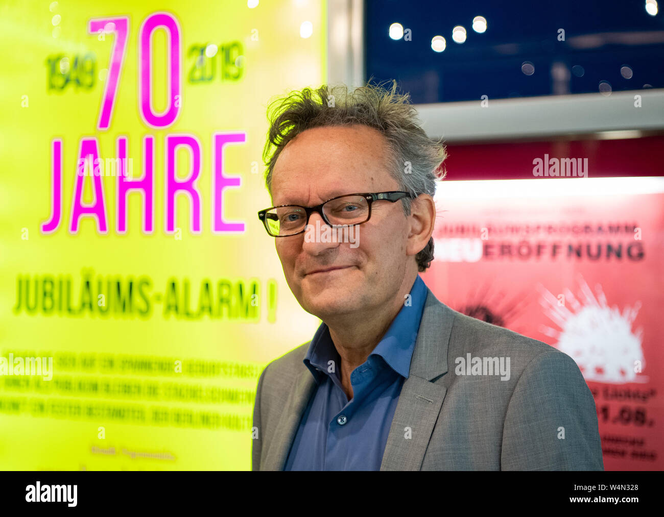 Berlino, Germania. Il 24 luglio, 2019. Frank Lüdecke, cabaret artista, è in procinto di avviare una conferenza stampa per il settantesimo anniversario di Berlino teatro cabaret 'Die Stachelschweine' accanto al poster per eventi. Credito: Soeren Stache/dpa/Alamy Live News Foto Stock