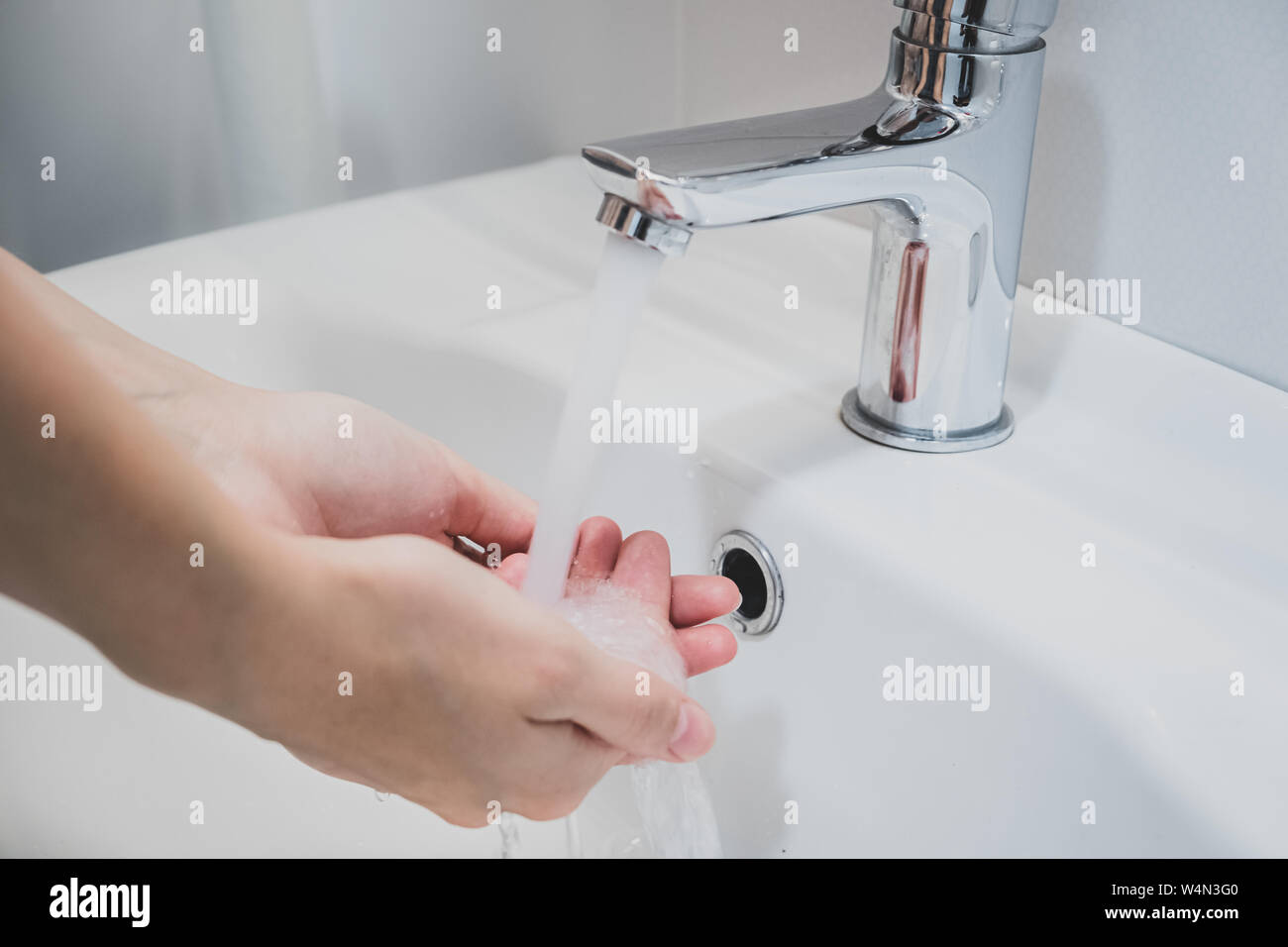 Lavarsi le mani con acqua in un lavandino. La pulizia delle mani, igiene personale concetto Foto Stock
