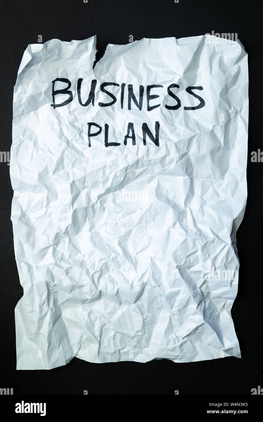 La frase " business plan " manoscritti su sgualciti carta strappata, vista dall'alto. Segno, concetto di piani non riuscita o cattiva gestione, astratta immagine illustrativa Foto Stock
