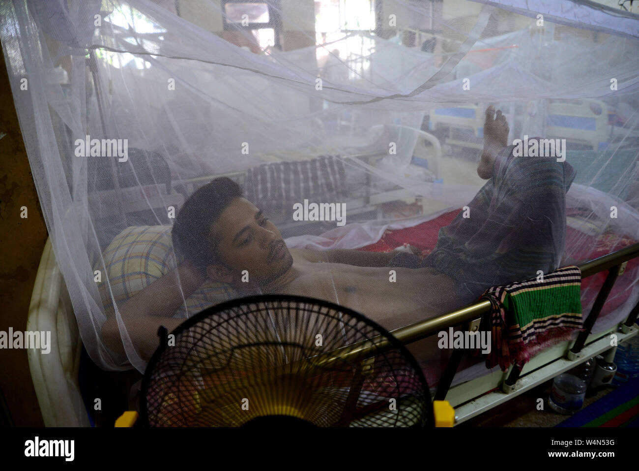 Un uomo coperto con una zanzariera soffre di febbre dengue come egli riceve il trattamento all'interno della 'haheed Suhrawardy' collega Medico Ospedale di DHA Foto Stock