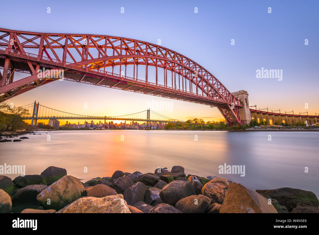 New York, New York, Stati Uniti d'America a Hell Gate Bridge al tramonto sull'East River. Foto Stock
