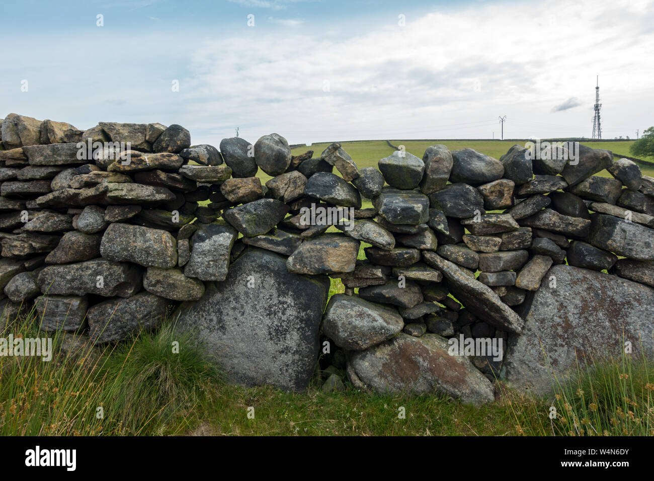 Un mal costruita in pietra a secco parete realizzata con grandi massi con fori in essa, nello Yorkshire, Regno Unito Foto Stock