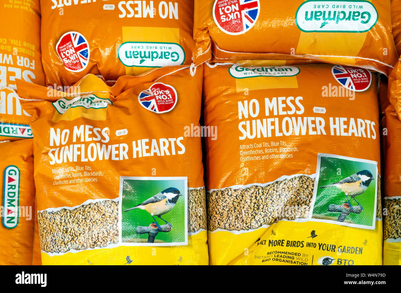 Una pila di sacchi di grandi dimensioni del marchio Gardman wild bird food nessun pasticcio cuori di semi di girasole per la vendita in un garden center in North Yorkshire, Inghilterra Foto Stock