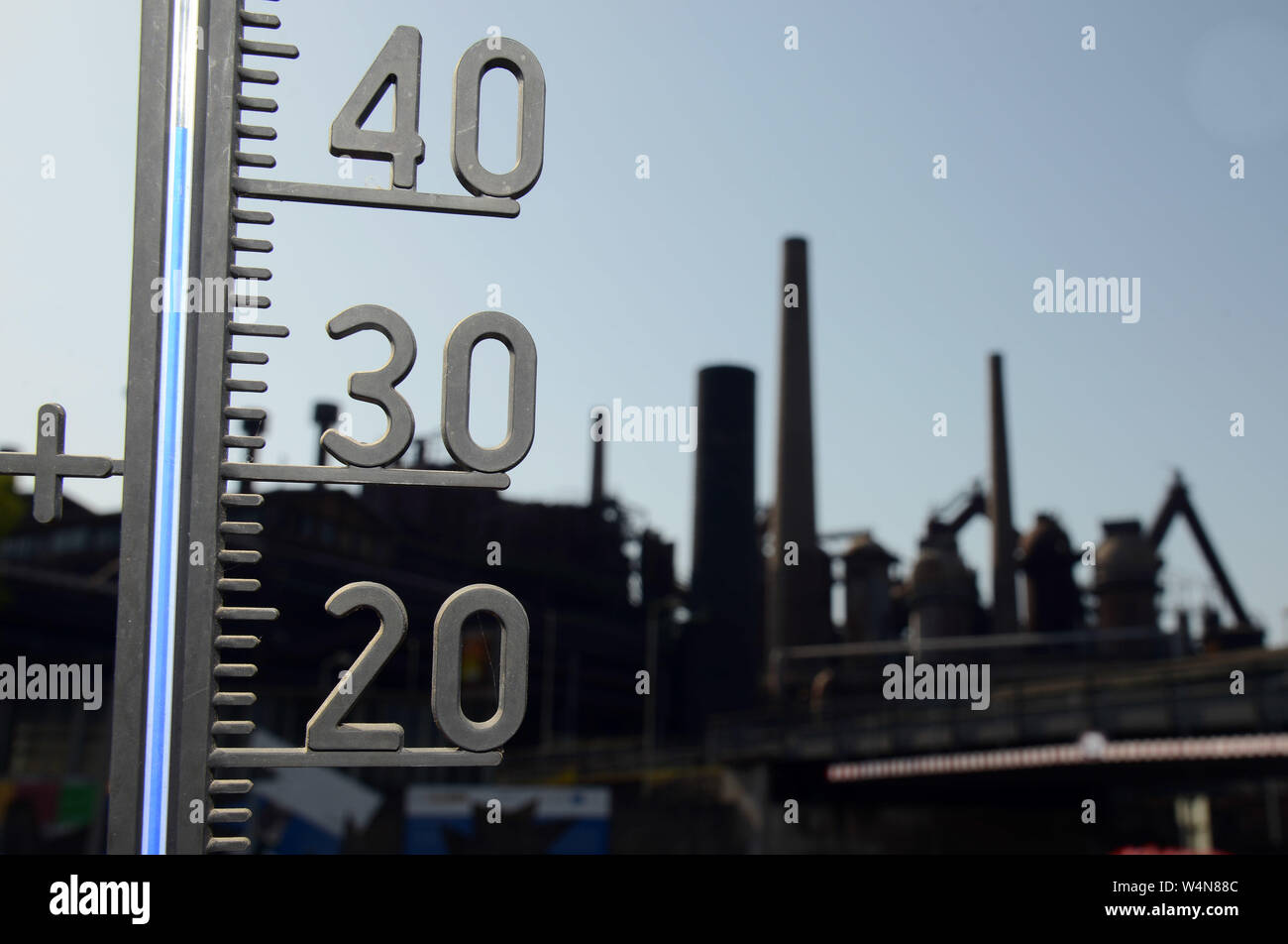 24 luglio 2019, Renania-Palatinato, Völklingen: il termometro nella parte anteriore del Sito del Patrimonio Culturale Mondiale Völklinger Hütte mostra oltre quaranta gradi al sole. Foto: Harald Tittel/dpa Foto Stock