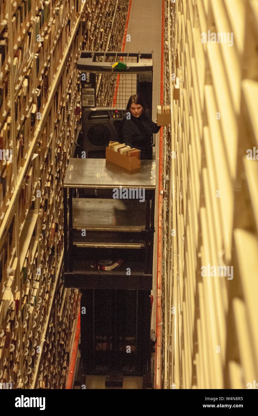 Elevato angolo di vista di una persona utilizzando un sollevatore motorizzato per selezionare i supporti da una pila alta, in un Milton S Eisenhower Biblioteca deposito, presso la Johns Hopkins University, Baltimora, Maryland, 13 febbraio 2006. Dall'Homewood raccolta di fotografie. () Foto Stock